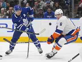 21 novembre 2022 ;  Toronto, Ontario, CAN ;  Le défenseur des Islanders de New York Ryan Pulock (6) et l'attaquant des Maple Leafs de Toronto Mitchell Marner (16) jouent pour la rondelle au cours de la première période à la Scotiabank Arena.