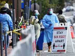 Les travailleurs supervisent la file d'attente dans un centre de test COVID-19 à Judiciary Square, Washington, le 18 novembre 2020.