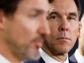 Bill Morneau, alors ministre des Finances, regarde le premier ministre Justin Trudeau lors d'une conférence de presse à Ottawa, le 11 mars 2020.