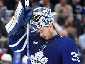 Le gardien de but des Maple Leafs de Toronto, Ilya Samsonov, ajuste son masque avant que le jeu ne reprenne contre les Blues de St. Louis en deuxième période à la Scotiabank Arena.