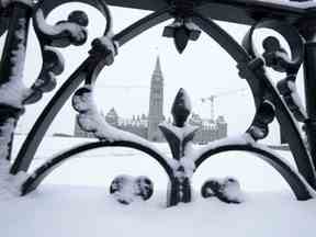 La neige recouvre une clôture entourant la Colline du Parlement, le vendredi 20 janvier 2023 à Ottawa.