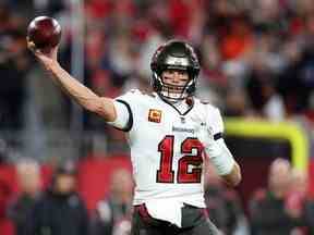 Le quart-arrière des Buccaneers de Tampa Bay, Tom Brady (12 ans), revient pour passer contre les Cowboys de Dallas lors d'un match de wild card au Raymond James Stadium.