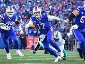 Le quart-arrière des Buffalo Bills Josh Allen (17 ans) s'éloigne du secondeur des Dolphins de Miami Jaelan Phillips (15 ans) au cours de la seconde mi-temps lors d'un match de la NFL au stade Highmark.