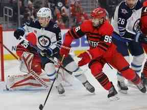 Le centre des Jets de Winnipeg Cole Perfetti (91) et le défenseur des Red Wings de Detroit Jake Walman (96) patinent au cours de la première période au Little Caesars Arena mardi soir.