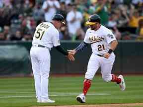 Stephen Vogt, à droite, de l'athlétisme court autour des bases après avoir frappé un coup de circuit contre les Blue Jays au RingCentral Coliseum d'Oakland, le 4 juillet 2022.