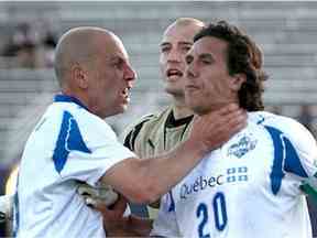 Le milieu de terrain de l'Impact de Montréal Sandro Grande, à gauche, attrape son coéquipier Mauro Biello à la gorge le 11 juillet 2009 au Minnesota.