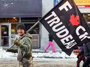 Un manifestant porte un drapeau montrant son mécontentement face aux mandats COVID imposés par le premier ministre Justin Trudeau, lors de la manifestation du Freedom Convoy à Ottawa, le 5 février 2022.