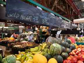 Les gens achètent des produits au marché de Granville Island à Vancouver, le mercredi 20 juillet 2022.