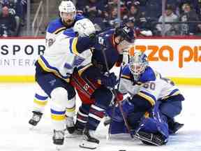 Le défenseur des Blues de St. Louis Torey Krug et le centre des Jets de Winnipeg Karson Kuhlman se battent pour un rebond devant le gardien des Blues Jordan Binnington au Canada Life Centre hier soir.  USA AUJOURD'HUI SPORTS