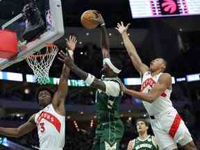 Bobby Portis des Bucks (au milieu) se dirige vers le panier contre OG Anunoby (à gauche) et Scottie Barnes au cours de la première mi-temps au Fiserv Forum à Milwaukee hier soir.