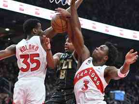 Dennis Smith Jr. (au centre) des Charlotte Hornets voit sa tentative de tir bloquée par Christian Koloko (à gauche) des Raptors et OG Anunoby au cours de la première mi-temps à la Scotiabank Arena le mardi 10 janvier 2023.