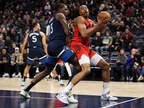 Scottie Barnes des Raptors cherche à tirer tandis que Nathan Knight des Timberwolves défend au cours du premier quart-temps au Target Center le jeudi 19 janvier 2023.