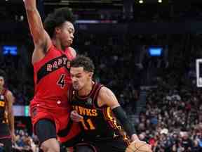 Le garde des Hawks d'Atlanta Trae Young (11) contrôle le ballon alors que l'attaquant des Raptors de Toronto Scottie Barnes (4) tente de se défendre au cours du deuxième quart à la Scotiabank Arena contre les Raptors de Toronto.