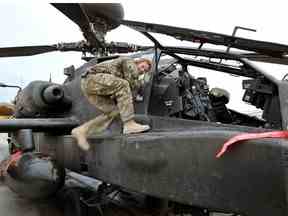 Dans cette image publiée le 21 janvier 2013, le prince Harry effectue des vérifications tôt le matin alors qu'il est assis sur un hélicoptère Apache sur la ligne de vol contrôlée par les Britanniques à Camp Bastion le 12 décembre 2012 en Afghanistan.