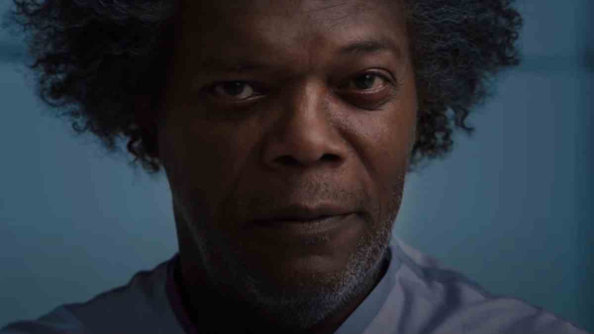 Samuel L Jackson wears an evil smile while sitting in the hospital in Glass.