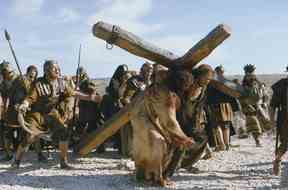 Jésus (Jim Caviezel) et Simon de Cyrène (Jarreth Merz), à droite, portent la Croix dans La Passion du Christ, un film de Mel Gibson.