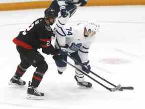 Le centre des Maple Leafs de Toronto Bobby McMann (74) et le défenseur des Sénateurs d'Ottawa Artem Zub (2) se battent pour la rondelle lors de la deuxième période d'action pré-saison de la LNH à l'aréna CAA de Belleville, en Ontario, le vendredi 30 septembre 2022.