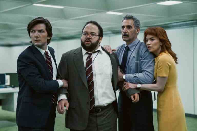 A group of employees in an office space huddle together as if in defense; still from "Severance."