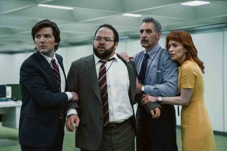 A group of employees in an office space huddle together as if in defense; still from "Severance."