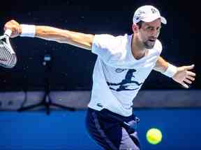 Le joueur classé numéro 5 mondial Novak Djokovic assiste à un match d'entraînement avec le joueur russe Daniil Medvedev avant le tournoi de tennis de l'Open d'Australie à Melbourne Park le 11 janvier 2023. (Patrick HAMILTON / AFP)