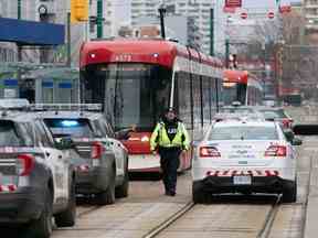 Des voitures de police entourent un tramway de la TTC sur l'avenue Spadina, à Toronto, le mardi 24 janvier 2023 après un incident au couteau.