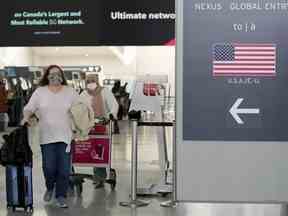 Les gens se rendent aux États-Unis d'Amérique à l'aéroport international Pearson de Toronto, le vendredi 3 décembre 2021.