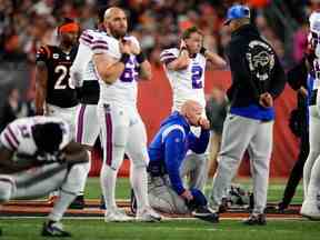 L'entraîneur-chef des Buffalo Bills Sean McDermott prend un genou alors que la sécurité des Buffalo Bills Damar Hamlin (3) est soignée sur le terrain à la suite d'une collision au premier quart contre les Bengals de Cincinnati au stade Paycor.