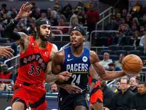 Le gardien des Indiana Pacers, Buddy Hield, passe le ballon tandis que le gardien des Raptors de Toronto, Gary Trent Jr., défend en seconde période au Gainbridge Fieldhouse.