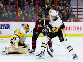 L'ailier gauche des Sénateurs d'Ottawa Austin Watson et le défenseur des Penguins de Pittsburgh Pierre-Olivier Joseph s'affrontent devant le gardien de but des Penguins de Pittsburgh Casey DeSmith lors de la troisième période de la LNH au Centre Canadian Tire le mercredi 18 janvier 2023.