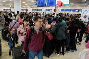 Les passagers des compagnies aériennes Sunwing font la queue pour l'enregistrement à l'aéroport international de Cancun après que de nombreux vols vers le Canada ont été annulés en raison des conditions météorologiques hivernales rigoureuses dans diverses régions du pays à Cancun, au Mexique, le 27 décembre 2022.