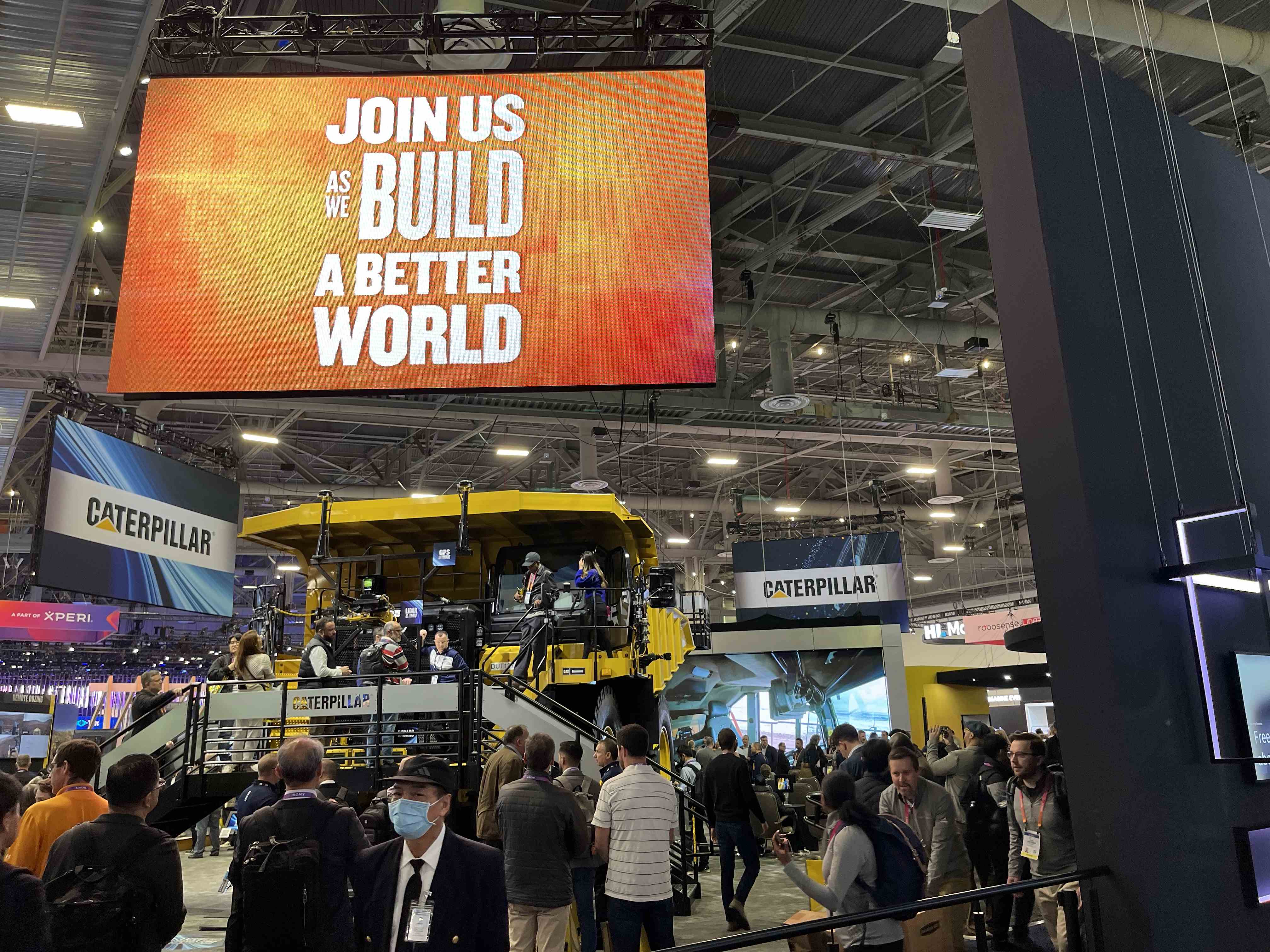 Un panneau Caterpillar au CES 2023 indique, "REJOIGNEZ-NOUS POUR CONSTRUIRE UN MONDE MEILLEUR."