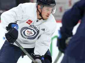 Nate Schmidt porte la rondelle à l'entraînement des Jets de Winnipeg le mercredi 23 mars 2022.