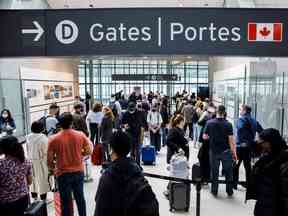 Les voyageurs envahissent la file d'attente de sécurité dans la salle des départs de l'aéroport international Pearson de Toronto à Mississauga, en Ontario, en mai 2022.