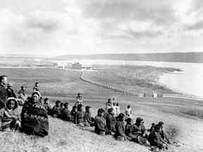 La nation crie de Star Blanket, au nord-est de Regina, a annoncé la découverte de possibles tombes après une recherche au radar pénétrant sur l'ancien site du pensionnat indien de Qu'Appelle.  Sur cette photo d'archive de mai 1885, des élèves autochtones, le père Joseph Hugonnard, principal, et le personnel, y compris les Sœurs grises, de l'école industrielle sont représentés à Fort Qu'Appelle, en Saskatchewan.