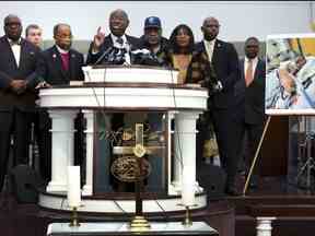 Flanqué des parents de Tire Nichols et des chefs religieux et communautaires, l'avocat des droits civiques Ben Crump parle à côté d'une photo de Nichols lors d'une conférence de presse le 27 janvier 2023 à Memphis, Tennessee.