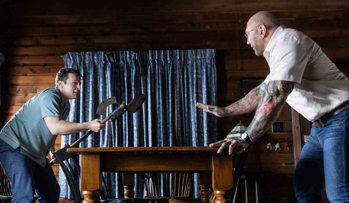 Eric (Jonathan Groff) et Leonard (Dave Bautista) se tournent autour d'une table, se disputant l'avantage lors d'un combat dans Knock at the Cabin