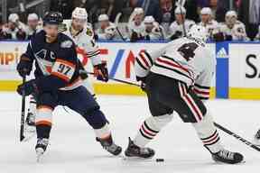 L'attaquant des Oilers d'Edmonton Connor McDavid (97) met la rondelle entre les pieds des défenseurs des Blackhawks de Chicago Seth Jones (4) au cours de la première période à Rogers Place le 28 janvier 2023. Perry Nelson-USA TODAY Sports