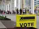 Des gens font la queue devant un bureau de vote pour voter lors d'une élection fédérale, à Toronto, le 20 septembre 2021.