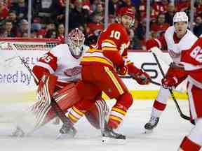 Jonathan Huberdeau des Flames de Calgary se bouscule pour la rondelle contre le gardien de but Magnus Hellberg des Red Wings de Detroit lors de la deuxième période au Scotiabank Saddledome le 16 février 2022 à Calgary, Alberta, Canada.