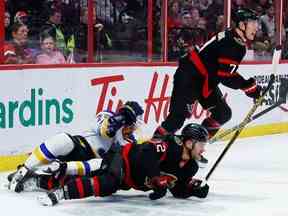 L'ailier droit des Sénateurs d'Ottawa Alex DeBrincat (12) et le défenseur des Blues de St. Louis Justin Faulk (72) s'emmêlent alors que l'ailier gauche Brady Tkachuk (7) suit le jeu en première période le dimanche 19 février 2023.