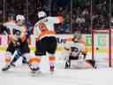 L'attaquant des Canucks de Vancouver Andrei Kuzmenko et le défenseur des Flyers de Philadelphie Travis Sanheim et le défenseur Ivan Provorov et le gardien Carter Hart regardent le tir de l'attaquant des Canucks Anthony Beauvillier passer Hart en première période au Rogers Arena.  18 février 2023.