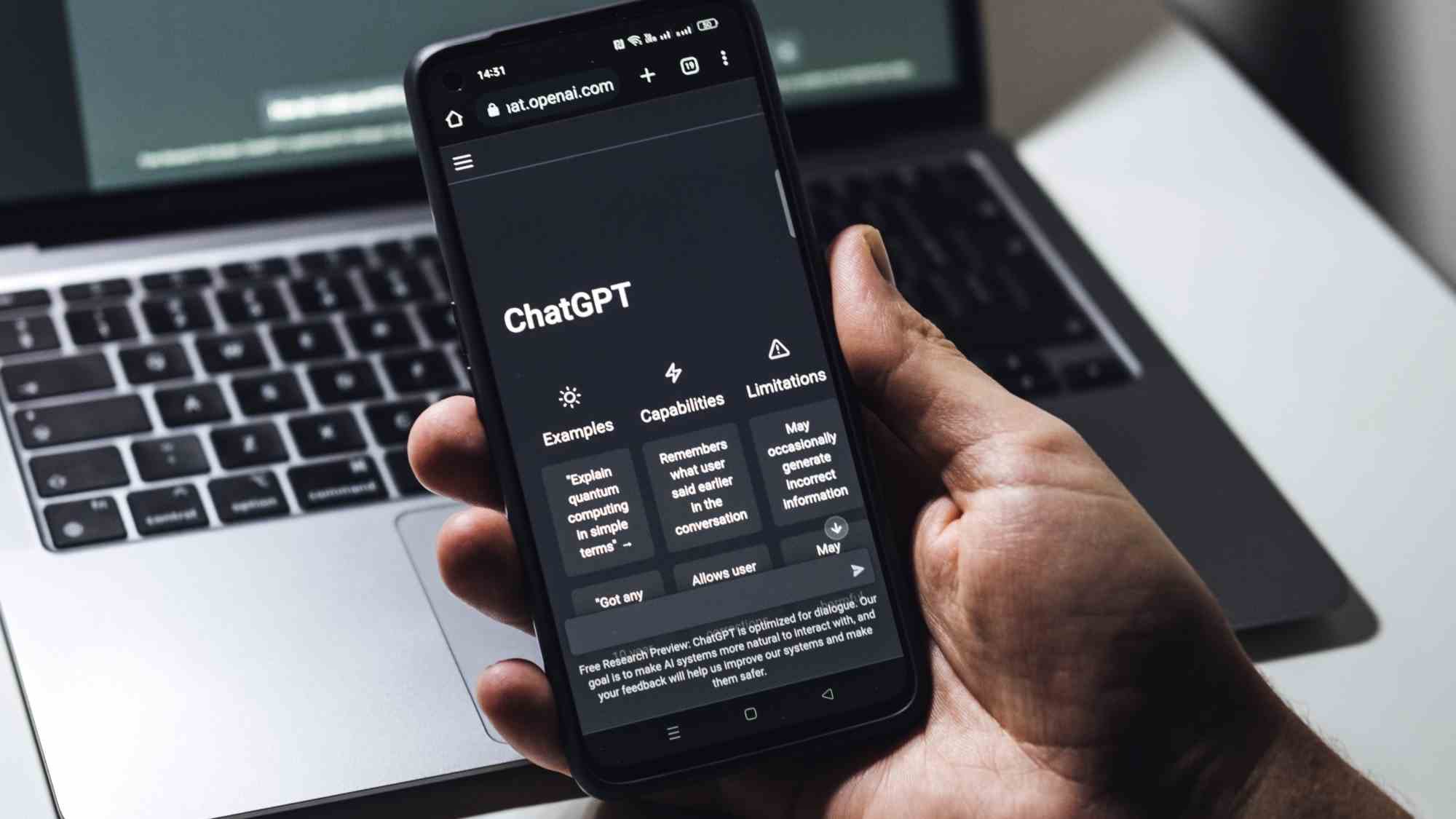 ChatGPT s'exécutant sur un téléphone avec un ordinateur portable en arrière-plan