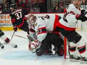 Avec le centre des Hurricanes Seth Jarvis sur son chemin après avoir été renversé par l'attaquant d'Ottawa Alex DeBrincat, le gardien des Sénateurs Cam Talbot est incapable d'empêcher la rondelle d'entrer dans le filet pour un but quelques secondes plus tard au cours de la première période du match.