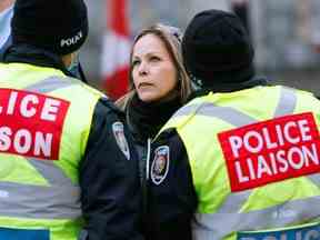 Tamara Lich, organisatrice du Freedom Convoy, s'entretient avec des policiers lors de la manifestation contre les mandats de la COVID-19, à Ottawa, le 10 février 2022.