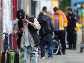 Des employés de la ville de Vancouver nettoient les trottoirs du Downtown Eastside avec une escorte policière à Vancouver, en Colombie-Britannique, le 19 juin 2022. (NICK PROCAYLO/PNG)