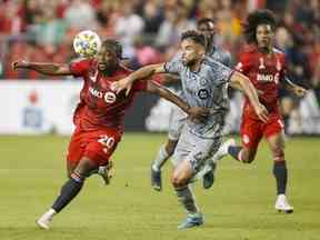 L'attaquant du Toronto FC Ayo Akinola et le défenseur du CF Montréal Rudy Camacho se battent au ballon lors de la première mi-temps de l'action de soccer de la MLS à Toronto le dimanche 4 septembre 2022.