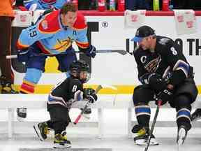 L'aile gauche des Panthers de la Floride Matthew Tkachuk (19) regarde l'aile gauche des Capitals de Washington Alex Ovechkin (8) s'entretenir avec son fils Sergei Ovechkin lors de la compétition d'habiletés des étoiles de la LNH 2023 au FLA Live Arena.