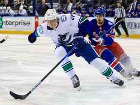 Le défenseur des Canucks de Vancouver Tyler Myers est poursuivi par l'ailier gauche des Rangers de New York Chris Kreider au cours de la deuxième période au Madison Square Garden.