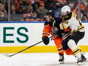 Jesse Puljujarvi des Oilers d'Edmonton affronte Derek Forbort des Bruins de Boston lors de la troisième période d'action de la LNH à Rogers Place à Edmonton, le jeudi 9 décembre 2021. Photo de Ian Kucerak