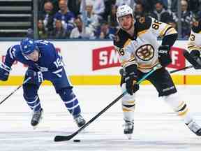 David Pastrnak des Bruins de Boston fait une passe devant Mitchell Marner des Maple Leafs de Toronto dans le troisième match du premier tour de la Conférence de l'Est lors des séries éliminatoires de la Coupe Stanley de la LNH 2019 à la Scotiabank Arena le 15 avril 2019 à Toronto, Ontario, Canada.